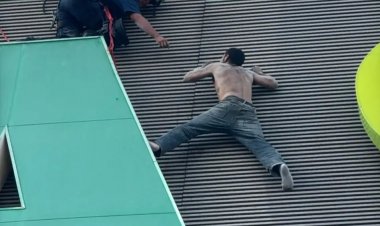 Un hombre en grave riesgo en las  alturas de una tienda, rescatado