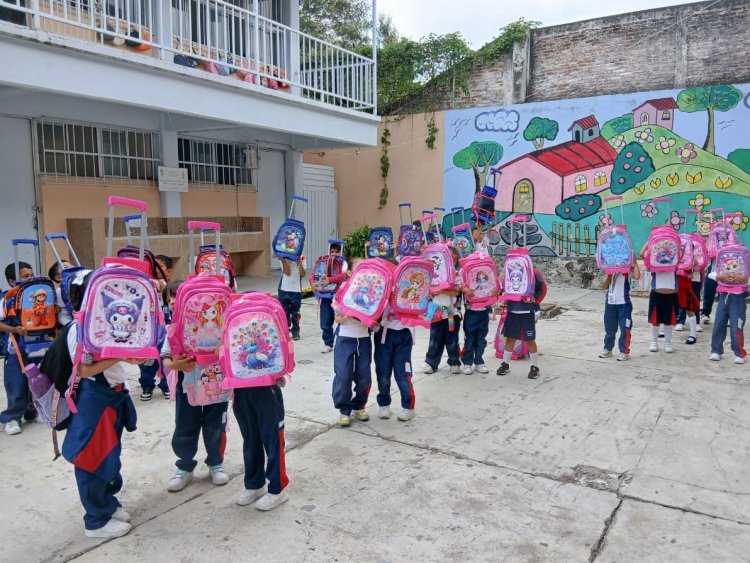 Los niños de 1° y 2° de  primaria, con mochilas